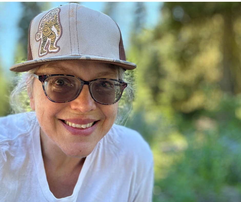 Hannah - Founder of Wild Squatch Wellness Hannah wearing a Bigfoot-themed hat, smiling in a natural forest setting with soft sunlight filtering through the trees.Hannah - Founder of Wild Squatch Wellness
